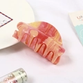 Macro detail of a marble-textured pink and yellow acrylic hair claw clip with subtle glitter - Starry Pink Marble