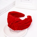 Detail of red velvet knotted headband on a white tray with an elegant book background - Red