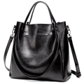 Minimalist black polished leather bucket bag with silver rivets and adjustable strap - Black