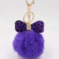 Detail of purple faux fur pompom keychain with leopard print bow and gold hardware - Purple