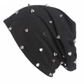 Détail du bonnet noir en tricot avec des rivets métalliques punk sur fond blanc neutre - Taille unique / Noir