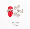 Dettaglio del fiocco metallico per unghie 7x13mm con strass AB su smalto rosso - Stile Strass AB Base Argentata (3285)