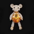 Macro shot of gold-plated bear pendant featuring yellow gemstone and white rhinestones - Gold Yellow
