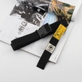 Black canvas tactical belt with yellow patch and plastic buckle on fashion magazine - Black