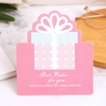 Pink gift box shaped greeting card with bow and best wishes text on marble table - Warm Gift