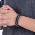 Triple-layer woven bracelet with black lava stones and silver beads on a male wrist - 6mm Three-row Hematite Lava Stone Bracelet