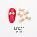 Détail de bijoux d'ongles nœuds dorés 4x7mm avec perles sur présentoir rouge - Base Dorée Six Perles Blanches (LF3257)