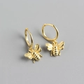 Detailed macro view of gold bee charms on hoop earrings with polished wing texture - One Pair / Gold