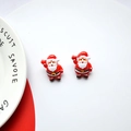 Close-up of dual Christmas Santa Claus resin earrings with red and white festive details - Raising Hands Santa