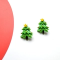 Detail shot of cute Christmas tree earrings with colorful ornaments on red and white background - Christmas Tree