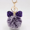 Close-up of purple plush ball keychain with a rhinestone studded polka dot bow - Two-tone Purple