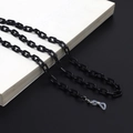 Detail shot of black acrylic eyeglass chain with silicone loops on a book surface - Black