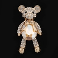 Detail of a gold bear brooch featuring champagne crystals and white rhinestones - Champagne