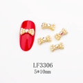 Dettaglio decorazione unghie a fiocco dorato 5x10mm con perle bianche e cristallo centrale - Stile Perla Bianca AB Base Dorata (3306)