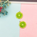 Detailed view of lime slice charms with green pulp and gold frame for DIY jewelry - Lime