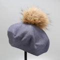 Detailed view of knitted wool beret in blue-grey with a large soft faux fur pompom - M (56-58cm) / Fog Blue