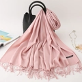 Pink cashmere scarf with tassels draped over a black leather tote bag in a soft setting - 200*70cm / Baby Pink