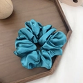 Peacock blue satin scrunchie with silk texture displayed on a wooden tray - Lake Blue