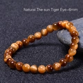 Bracciale di perle in occhio di tigre naturale da 6mm su fondo in pietra scura - Occhio di Tigre Solare Naturale (6mm)