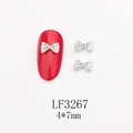 Détail du bijou d'ongle nœud argenté avec perle et strass, taille 4x7mm sur ongle rouge - Base Argentée Perle Strass Blanc (LF3267)