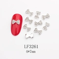 Vue macro de bijou ongle nœud en alliage avec strass et dimensions 4x7mm - Base Dorée Strass Mixtes (LF3261)