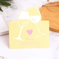 Carte de vœux jaune avec verres à champagne et cœur rose sur fond de marbre - Verre Cheers