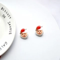 Close-up of handmade Santa Claus resin earrings on a decorative white porcelain plate - White Santa Claus