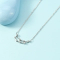 Silver Capricorn constellation necklace with clear zircons on a light blue background - Capricorn