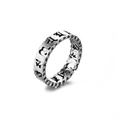 Detalle macro de anillo punk vintage con escrituras budistas religiosas grabadas en él - Mantra de Seis Caracteres B