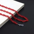 Close-up of bright red acrylic eyewear chain with adjustable silicone loops on a book - Red