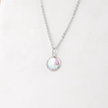 Primer plano de colgante redondo de 12mm con escamas de pez iridiscentes en collar plata - Arcoíris Holográfico
