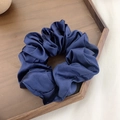 Elegant navy blue silk satin scrunchie ponytail holder displayed on a rustic wood tray - Sapphire Blue