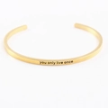 Détail du bracelet jonc doré en acier inoxydable gravé You Only Live Once - on ne vit qu'une fois