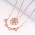 Collana a quadrifoglio in oro rosa con strass scintillanti e piccoli ciondoli a cuore - Oro Rosa + Bianco