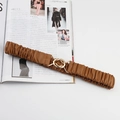 Brown elastic wide waist belt with golden interlocking circles on fashion magazine - Camel