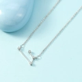 Silver zodiac constellation necklace with sparkling stones on light blue background - Aries