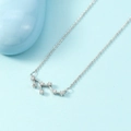 Silver zodiac constellation necklace with small sparkling cubic zirconia on a light blue background - Leo