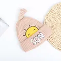 Detail van gebreide babymuts met geborduurd zonnetje en witte pluche SUN-letters - Kinderen (44-52CM) / Beige