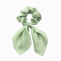 Close-up of mint green satin hair scrunchie with bow tie and smooth silk texture - Light Green