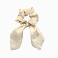 Detail of cream satin hair scrunchie with long ribbon bow on white background - Beige