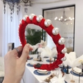 Handmade red velvet headband with large white pearls shown in a close-up handheld view - Red