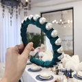 Emerald green velvet headband with large pearls, held in a sophisticated indoor setting - Green