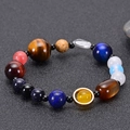 Solar system bracelet with tiger eye and natural stones on dark textured background - Planet Bracelet Style