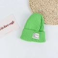Detail of bright green ribbed knit beanie showing soft texture and fabric label - Head Circumference 50-58cm / Grass Green