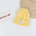 Close-up of a bright yellow ribbed knit beanie featuring a minimalist white woven label - Head Circumference 50-58cm / Yellow