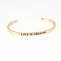 Gold stainless steel C-shaped cuff bracelet engraved with Love Is Greater text - LOVE IS GREATER