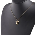 Macro detail of gold Taurus zodiac necklace with a dark gemstone on a black bust - 2-2 Taurus