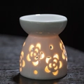 White ceramic floral cutout aromatherapy oil burner with warm candle light glowing through - Smiley Face / Aromatherapy Burner + Candle Tray