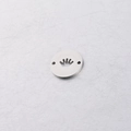 Close-up of a stainless steel circular pendant featuring a crown cutout and two small holes - Crown Steel Color