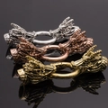 Gros plan de trois fermoirs tête de dragon en argent, bronze et or avec écailles - Tête de Dragon / Rose vif